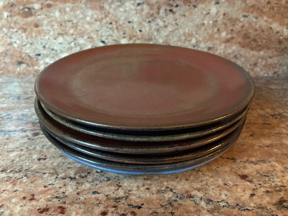 The set of plates on Brooklyn red clay, stacked to show their various glazes, the bottom one blue